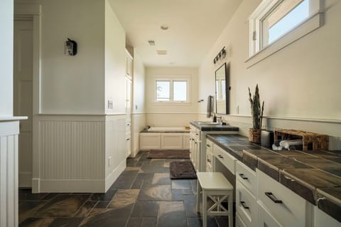 Full bathroom featuring a built-in tub under bright windows.