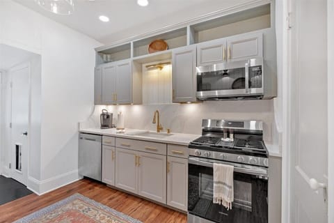 The kitchen is fully quipped with sleek stainless steel appliances, including a modern refrigerator, stove, and dishwasher.