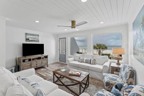 Bright living space with ocean views, sofas, and TV.