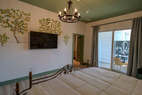 Features a King bed, hand-painted mural, and cozy finishes with balcony access