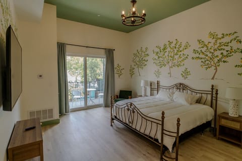 Bright and airy king room with private balcony and cheerful mural accents