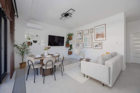 The bright living room with a large TV and a comfortable sofa creates the perfect spot for relaxation and cozy evenings together.