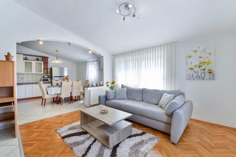 Open-plan living room with sofa, dining area, kitchen, WiFi internet, and satellite TV