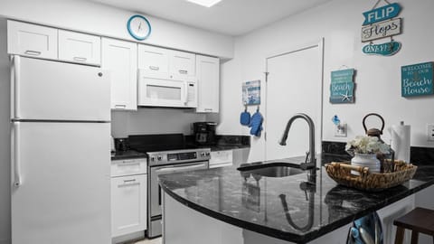 Fully equipped kitchen with modern appliances and breakfast bar seating.