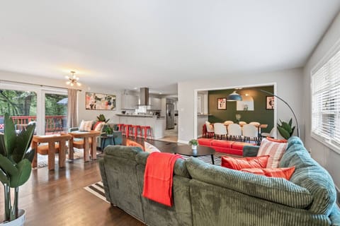 Open‑concept main level where living, dining, and the kitchen connect and flow to the deck.