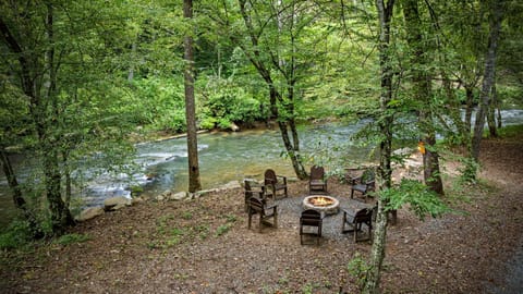 Fireside nights under string lights by the creek 🔥