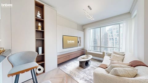 Step into a sunlit space with floor-to-ceiling windows, premium sofa, sleek Smart TV, and contemporary décor. Perfect for relaxing, streaming, or soaking in Downtown Dubai skyline views—ideal for families, couples, and remote workers.