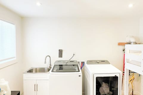 Full laundry room with washer, dryer, and utility sink