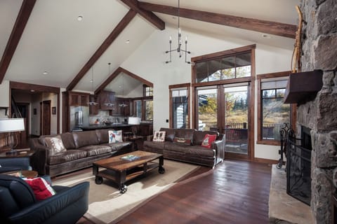 Gather by the stone fireplace in a soaring, light-filled great room.