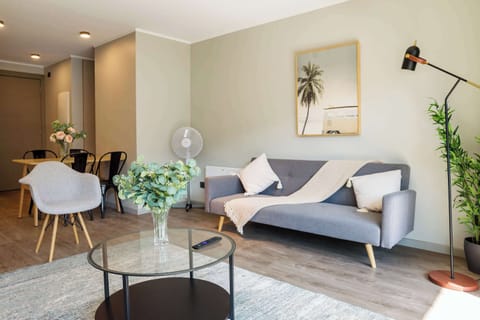 Relax in this stylish living room with modern decor and ample natural light, perfect for unwinding after exploring the city.