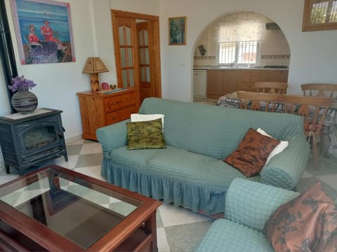 A view toward the arch leading into the kitchen; sofa, the wood-burning stove.