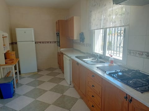 A view of the kitchen; gas hob; fridge- freezer; work-top.