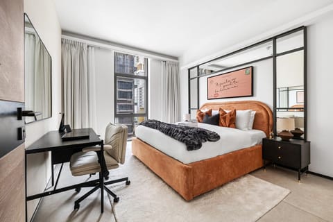 Neatly made bed with soft tones and View