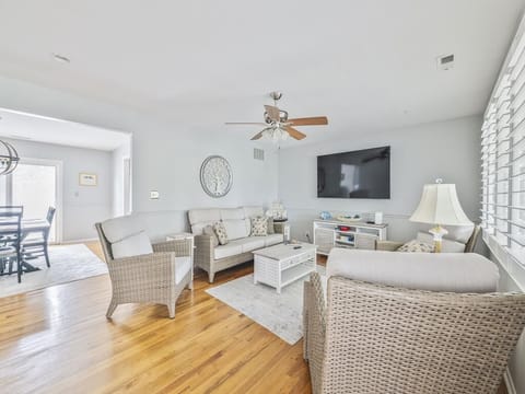Experience comfort in the living area, complete with cozy furnishings, a flat-screen TV, and warm wood flooring, perfect for family gatherings and quality time.