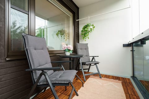 Cozy and inviting balcony space featuring two cushioned chairs and a small round table—perfect for enjoying morning coffee or relaxing outdoors