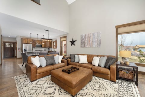 Unwind in your spacious living area with rich leather sectional and stunning natural light streaming through expansive windows.