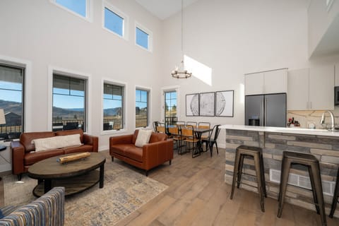 Relax in your spacious open-plan living area with soaring ceilings, where leather seating and modern kitchen create the perfect space for gathering.