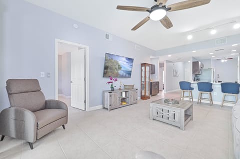 MB102 - Reclining sofa end seats & chair and large smart TV in the living.