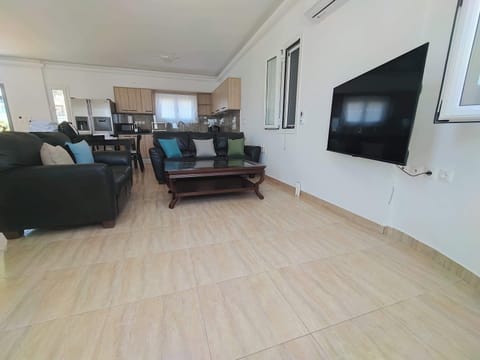 Modern Living Room with Entertainment Amenities
Stylish seating area with a flat-screen TV, perfect for unwinding after a day exploring Kythira. The open-plan design blends comfort with convenience.