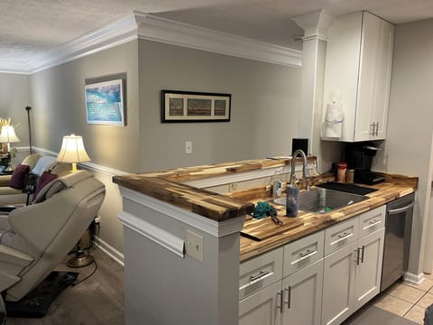 Condo features an open kitchen, dining, and living area.