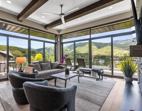 The living room has a wall of windows with views of Deer Valley Resort and Park City Mountain Resort including the Canyons.