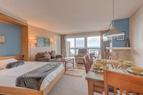 The Ocean View Queen Bed Studio features a cozy queen Murphy bed alongside a comfortable sitting area and a dining space with elegant decor.
