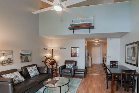 Open-concept layout with leather seating, dining table, and a loft-style design leading into the full kitchen.