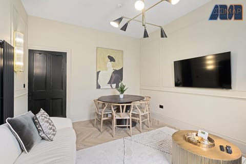 Relax in style with a spacious living room featuring a 50" Smart TV, a large sofa that comfortably seats four, and a cozy coffee table with seating for two—perfect for movie nights or winding down after a day out.