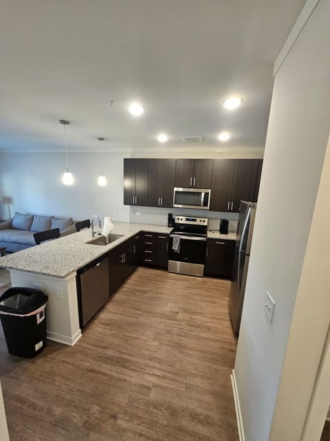 Modern kitchen featuring granite finishes, stainless-steel appliances, and open access to the living room for easy entertaining.