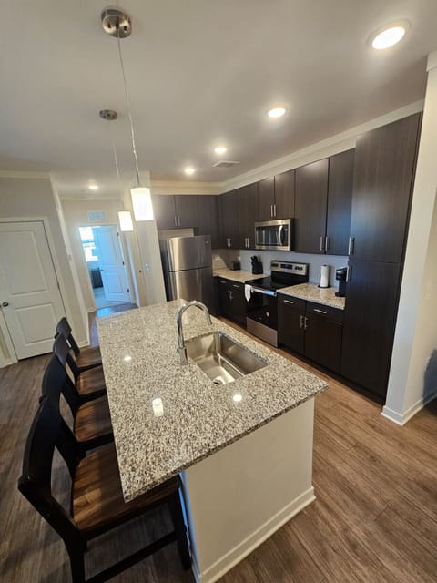 Fully equipped kitchen featuring sleek cabinetry, granite island, and stainless-steel appliances — perfect for extended stays.