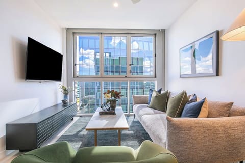 Unwind on plush seating with a movie on the wall-mounted TV, while panoramic windows flood the space with natural light and frame stunning views of the Fortitude Valley skyline.