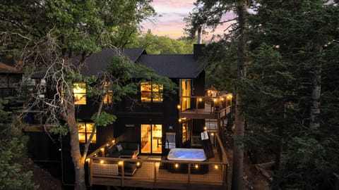 Evenings glow at Raven Ridge with warm exterior lights, a bubbling hot tub under the stars, and a cozy fire pit—your private forest oasis.