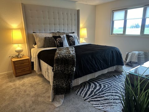 Spacious master bedroom featuring a king bed, quality bedding, and a calm, comfortable atmosphere.