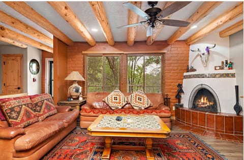 Stunning southwestern living area with a wood burning kiva provides plently of lounging space.