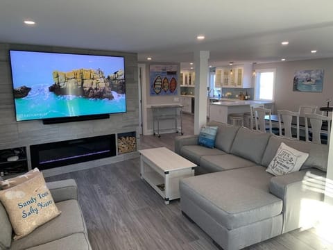 Spacious living area with sectional seating, fireplace, and large-screen TV—perfect for movie nights and gatherings.