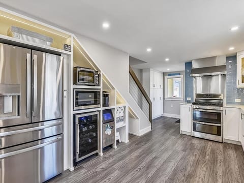 Bright, modern kitchen featuring two dishwashers, beverage cooler, and chef’s gas stove—designed for effortless group meals and entertaining.