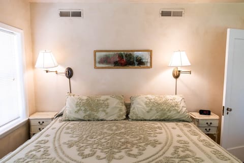 King bed with vintage linens—relax in soft light and classic comfort