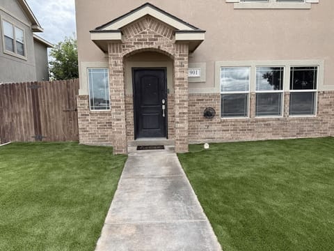 Step up to Sunset Retreat — a freshly landscaped front yard with new turf and a tidy walkway leading right to your door.