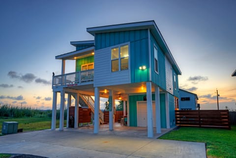 Twilight curb appeal of the elevated beach house.