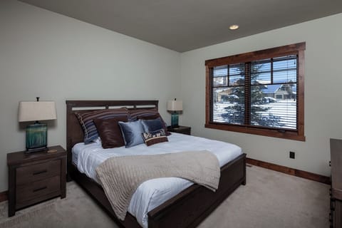 Drift off in a serene bedroom with views of snowy pines.