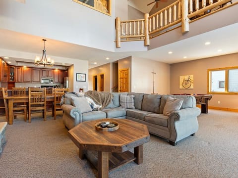 Unwind in your spacious living room featuring a plush sectional sofa, game table, additional seating and open loft design that creates an airy, welcoming atmosphere.