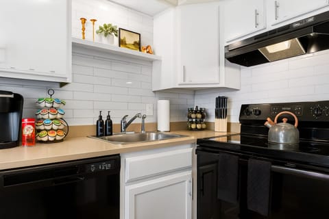 Sleek and modern kitchen, granite countertops, and a coffee station.