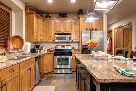 Rustic wood cabinetry and slate floors pair with stainless steel appliances for easy in-home cooking. PPS-1416