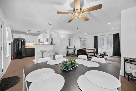 Above the table, a light fixture with a rustic yet elegant feel hangs low, casting a soft, amber glow that adds warmth to the room.