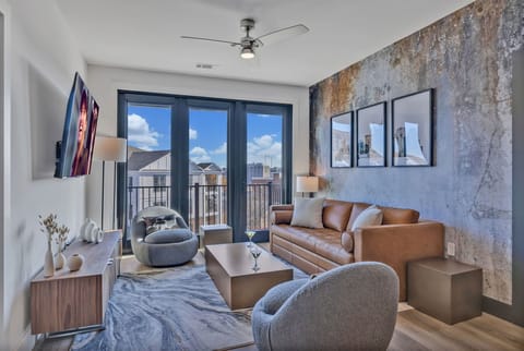 Unit 4: Bright living room with comfortable seating, smart TV, designer decor, and access to the private patio.
