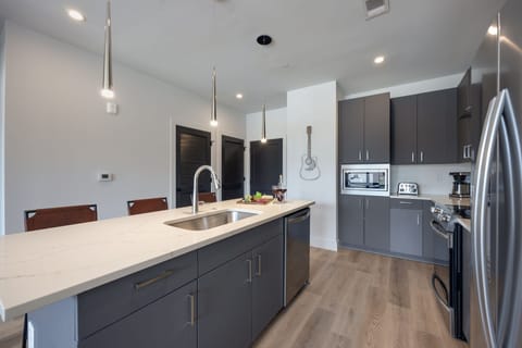 Unit 1: Fully equipped kitchen with brand-new stainless-steel appliances and a Kitchen island that offers ample counter space and bar seating.