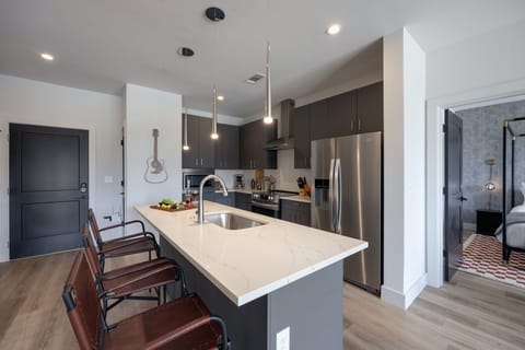Unit 1: Fully equipped kitchen with brand-new stainless-steel appliances and a Kitchen island that offers ample counter space and bar seating.