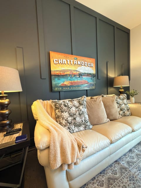 Inviting beige leather sofa with soft pillows against a warm accent wall.
