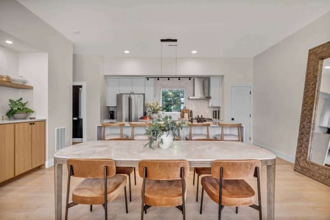 Gather around a stylish dining table with seating for six, perfectly set beside a sleek modern kitchen for home-cooked meals and memorable moments.