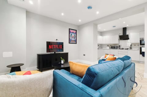 Living space with a velvet sofa, full kitchen, and dining area